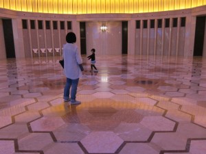 Child dancing in the rotunda between escalators