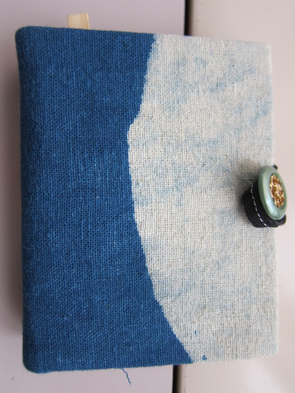 The book is about 4 inches square and closes with a button.